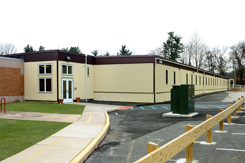 A building with a parking lot and fence located in Pedricktown, NJ