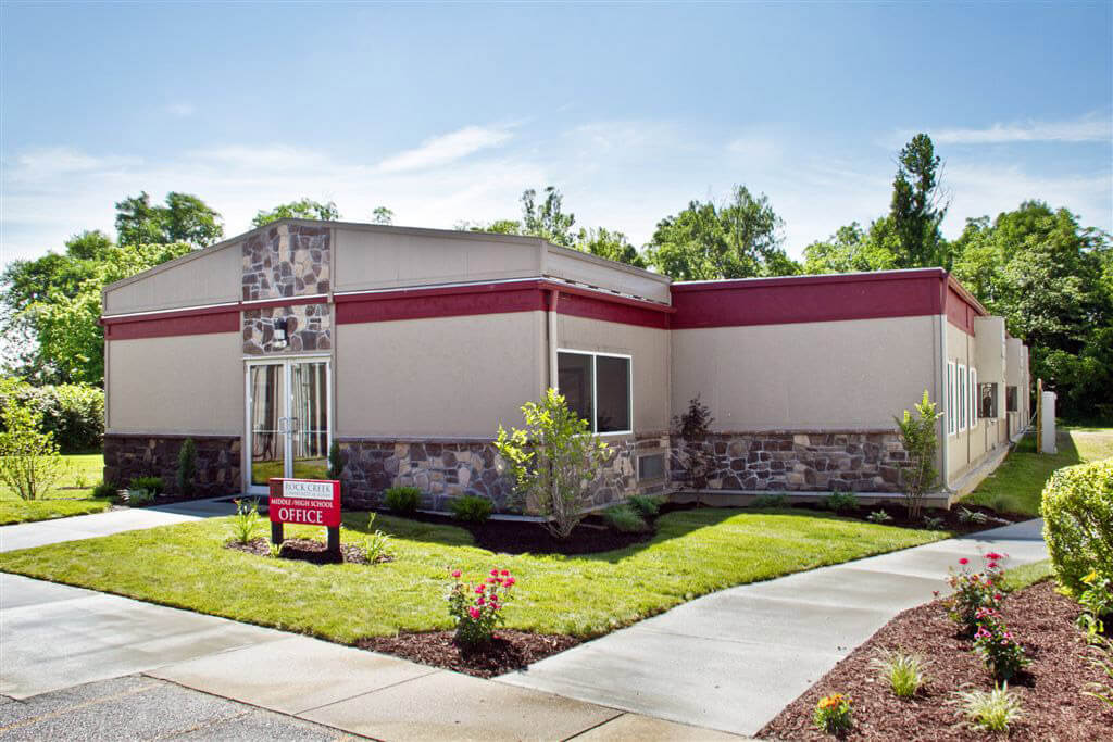 A small stone building with a red roof, serving as Sales Offices in Pedricktown, NJ