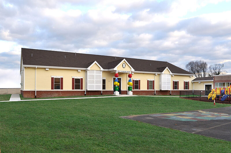 Yellow house with a play area in front, located featuring a Modular Classroom in Pedricktown, NJ