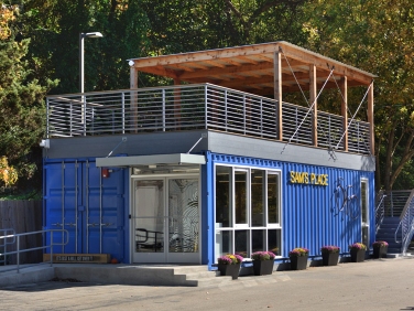 Blue shipping-container office with rooftop deck and glass entrance in Pedricktown, NJ