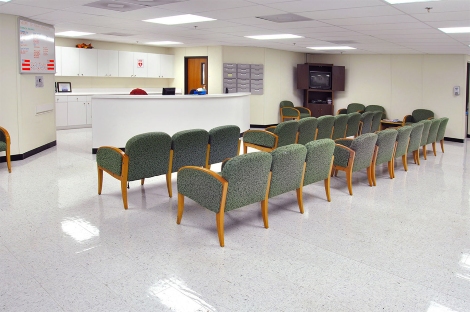 Bright modular healthcare waiting room with rows of chairs & reception counter in Pedricktown, NJ