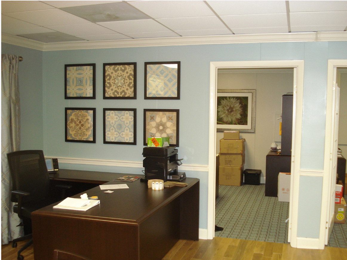 Modular sales office interior with desk, wall art, and adjoining room in Pedricktown, NJ