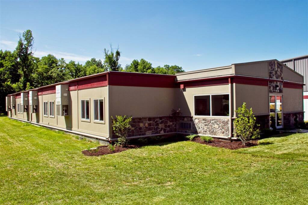 Low-rise modular sales office showcasing tan walls and an expansive green lawn in Pedricktown, NJ