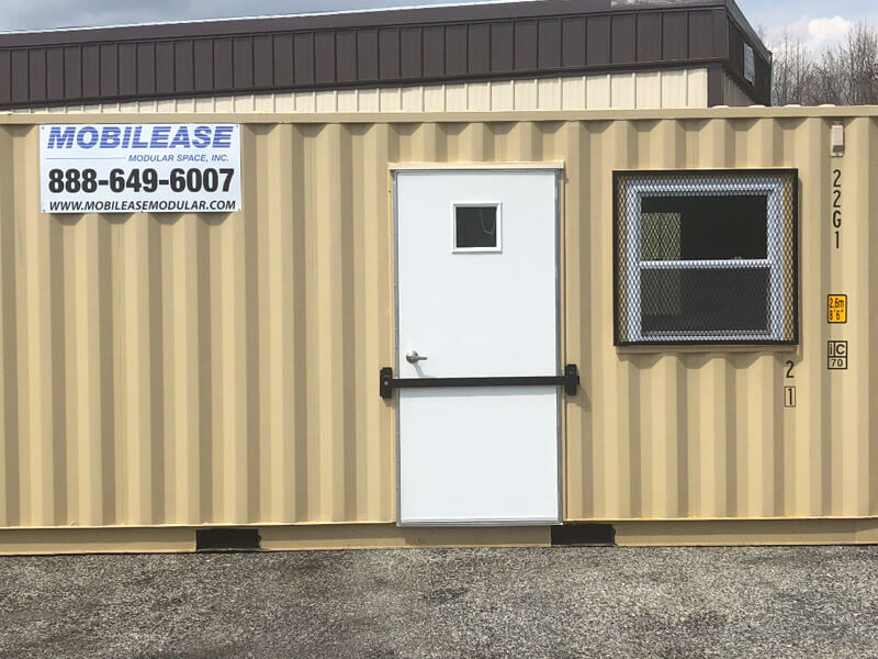 Tan portable office container with a white door and window grate in Pedricktown, NJ