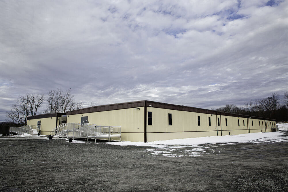 Long beige flexspace modular building with windows and ramps Mobilease Modular Space