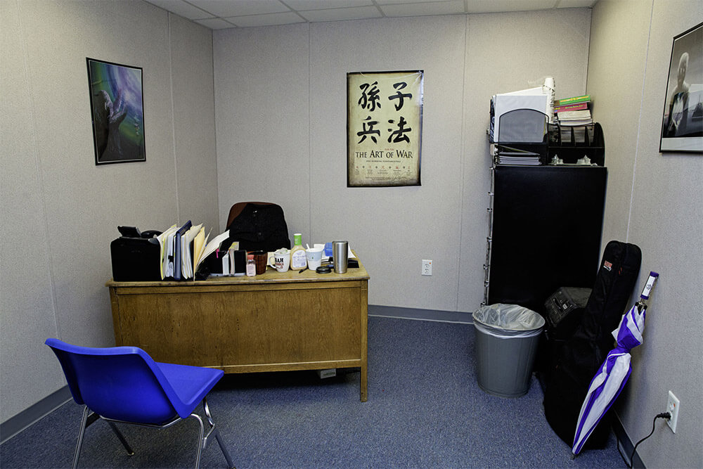Small flexspace modular office by Mobilease Modular Space with a wooden desk and a blue chair