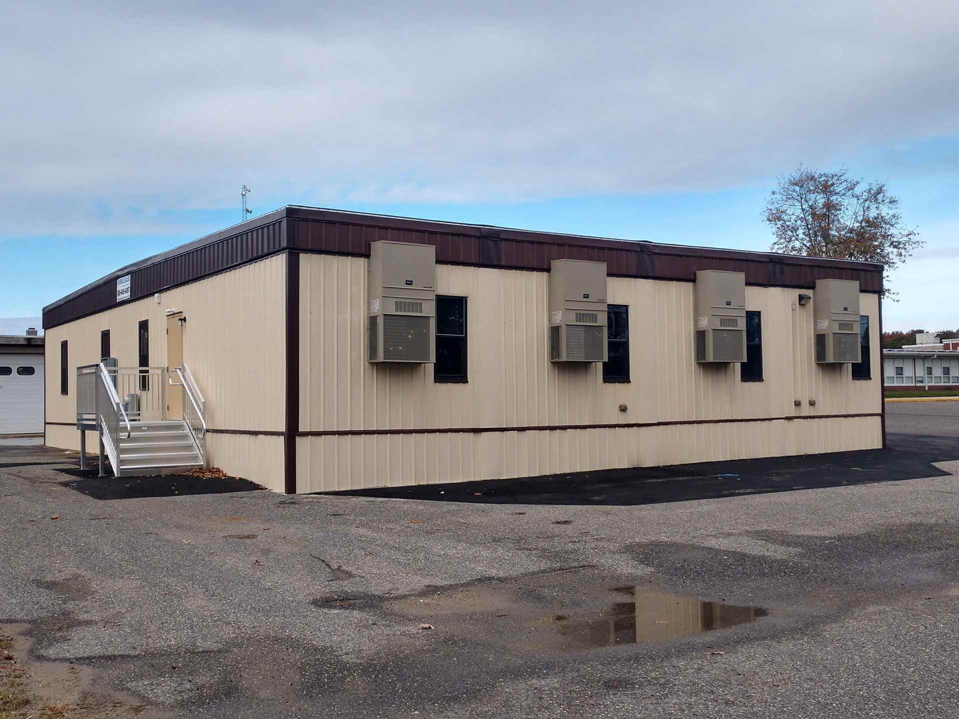 Gray Mobilease Modular Space, a modular commercial office building, & cars parked outside the office