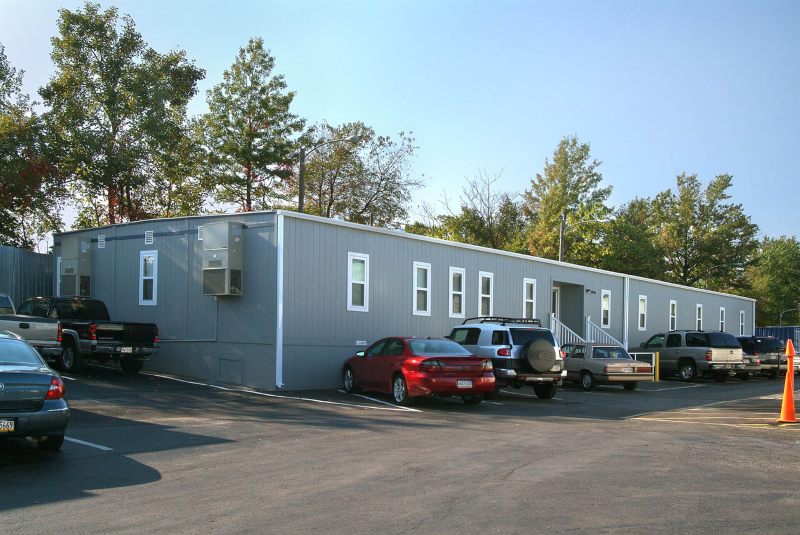 Commercial modular office building with parking lot and vehicles outside
