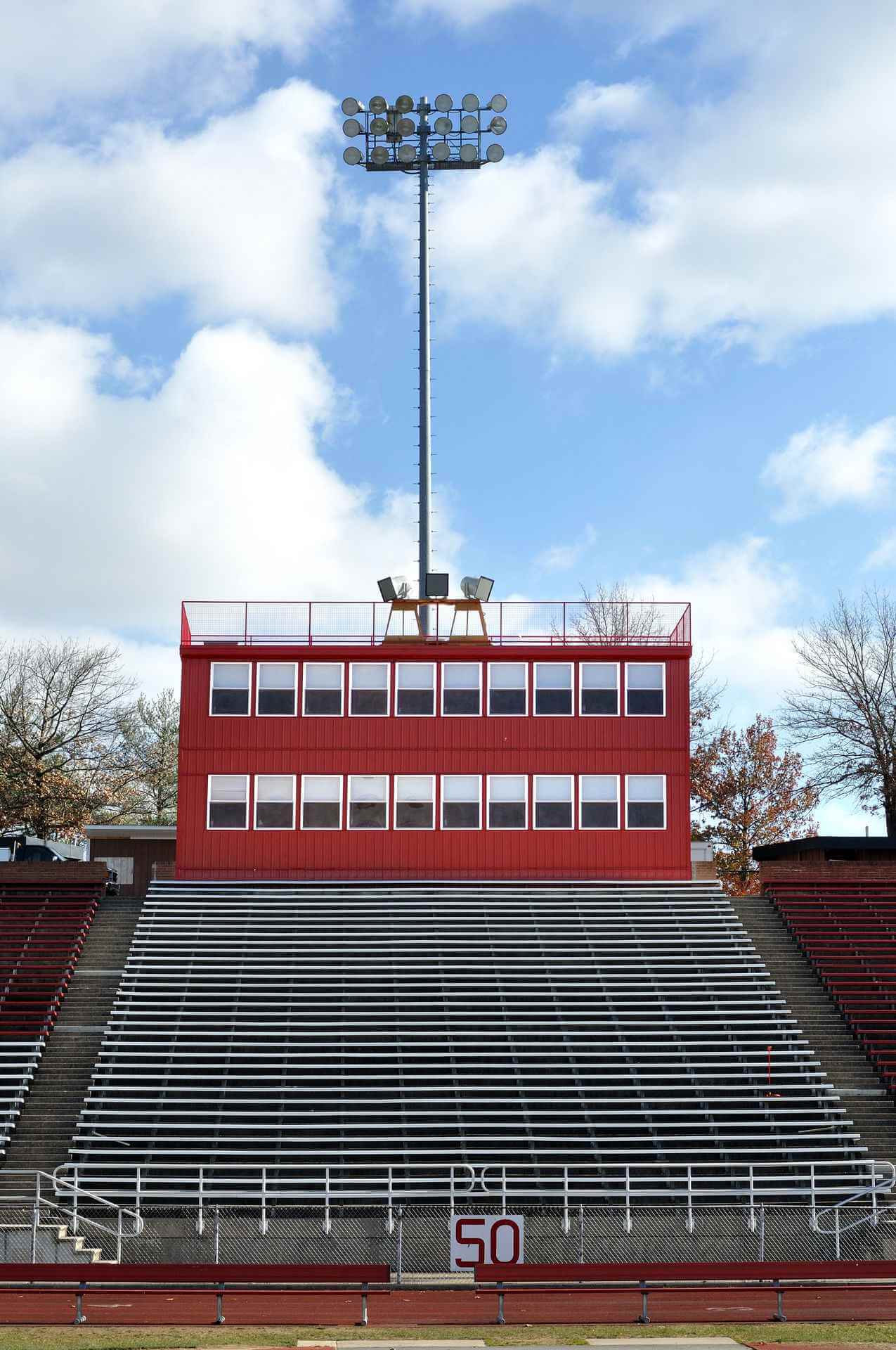 Stadium bleachers & Mobilease Modular Space modular commercial red press box with lighting tower
