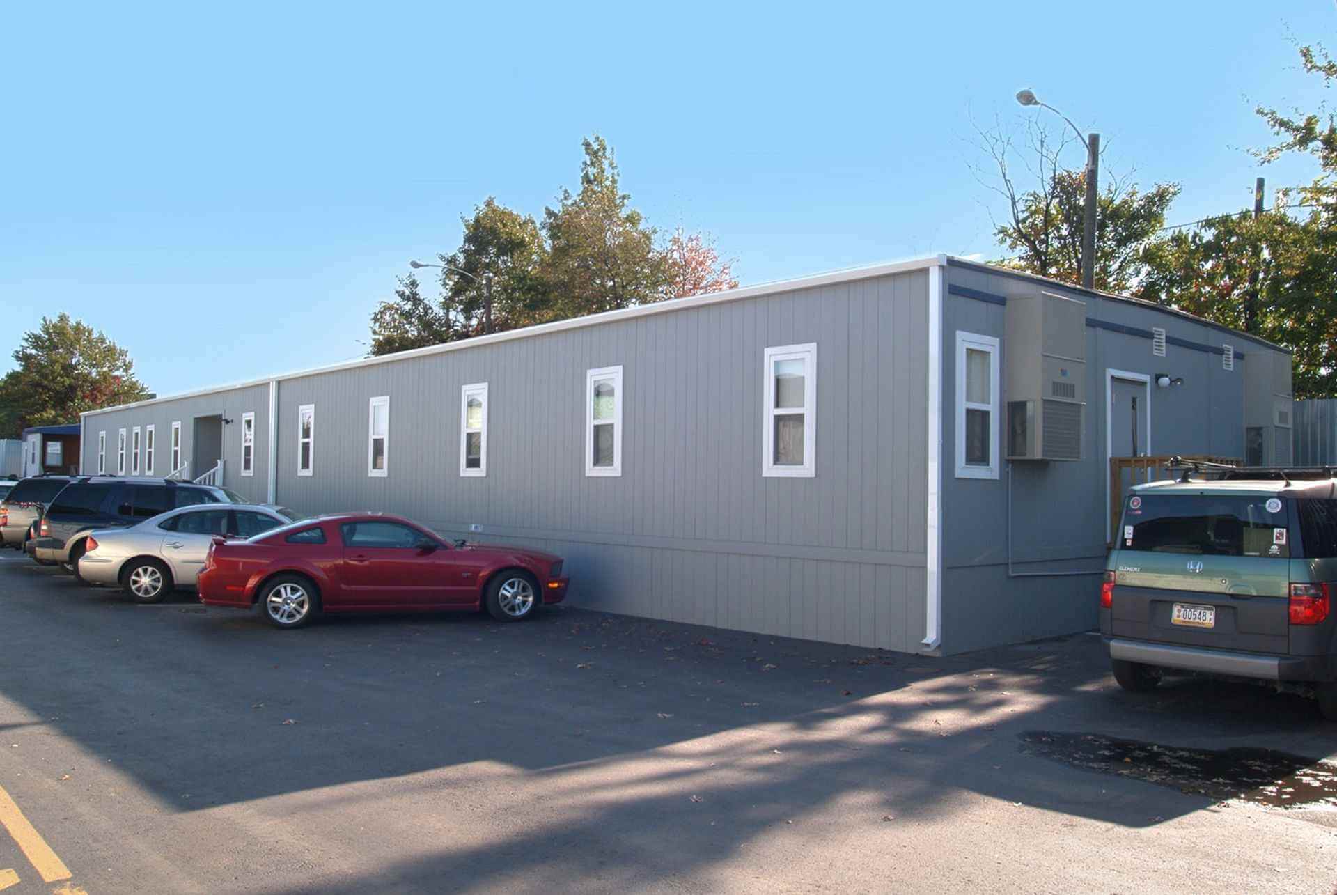 Beige Mobilease Modular Space, a modular commercial office building with multiple exterior AC units