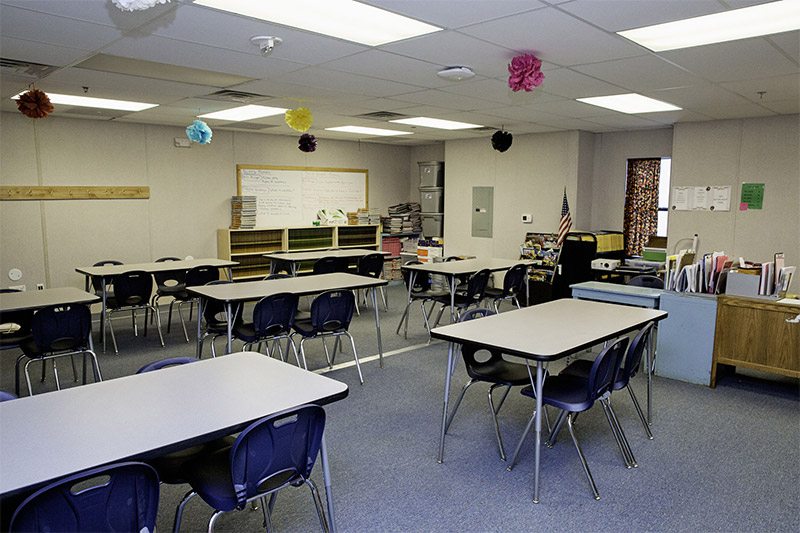 Modular classroom building with accessible entrance, wraparound deck, and landscaped grounds
