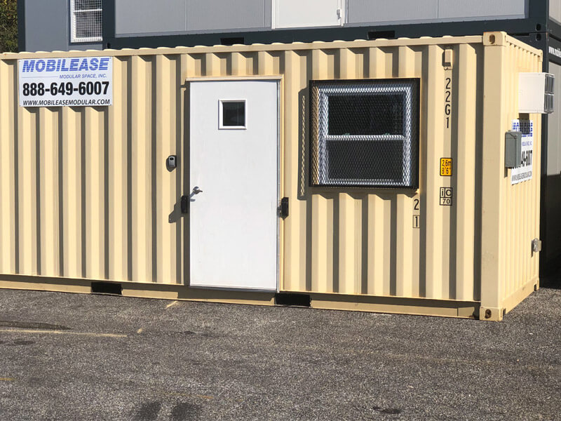Beige modular construction office by Mobilease Modular Space with a secure window.