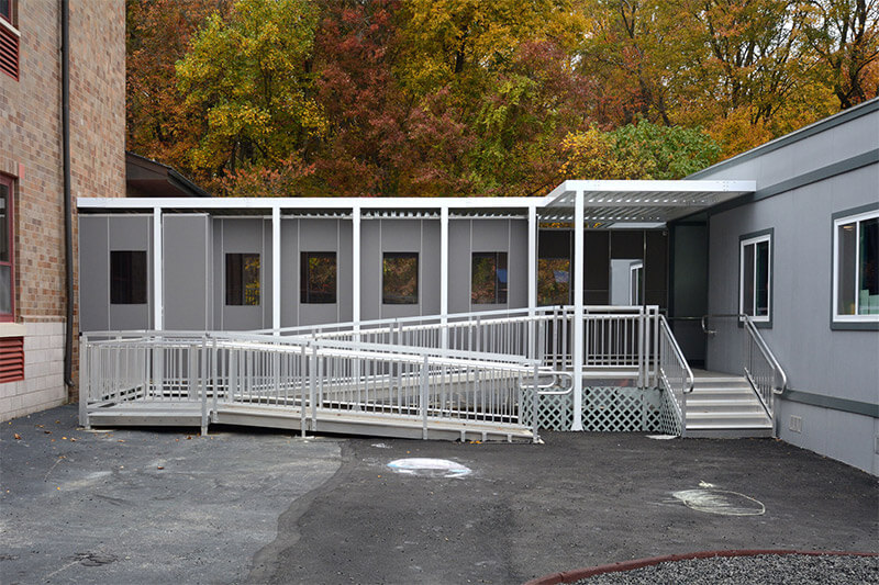gray-modular-classroom Gray modular classroom by Mobilease Modular Space with a covered ramp and stairs.