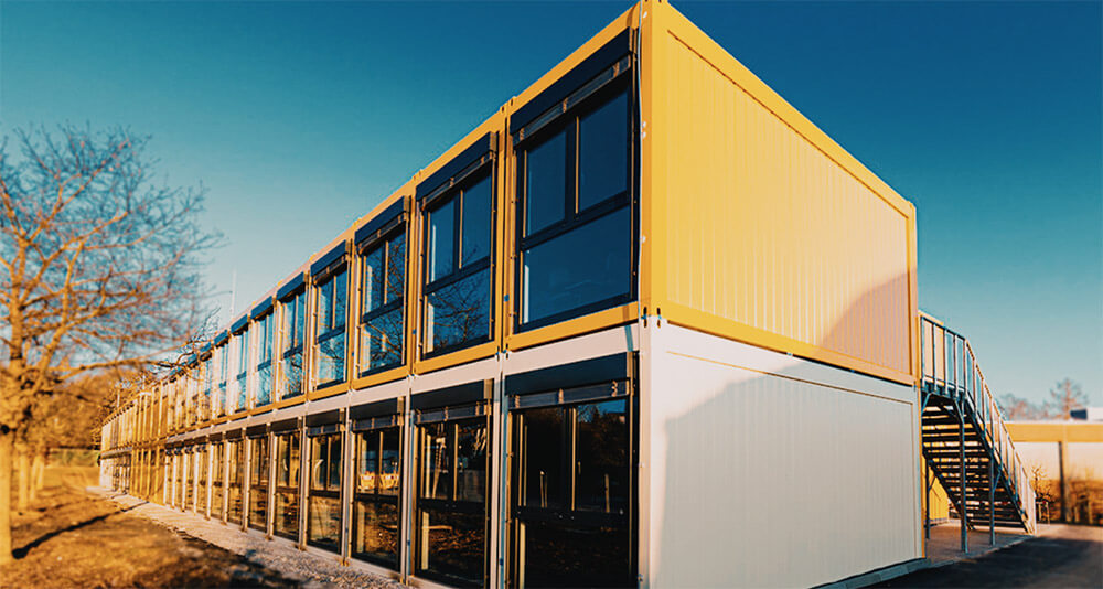 Yellow and white MMS-160 modular building by Mobilease Modular Space and an outdoor staircase.